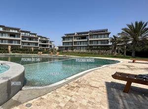 een zwembad voor sommige appartementsgebouwen bij 2BR Apartamento Moxie Paracas con Terraza y AC en 1r Piso in Paracas