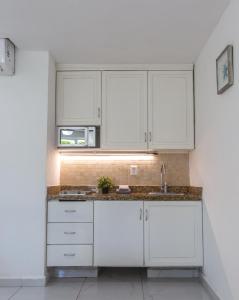 una cocina con armarios blancos y fregadero en 1209 Beautiful Beach Studio on Hotel Zone, en Cancún
