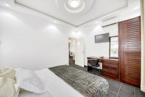 a bedroom with a bed and a desk and a television at Cosy Home in Douala