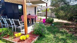 een patio met een tafel en stoelen in een tuin bij Kumera Home in Gold Coast