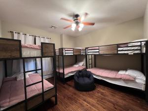 Habitación con 4 literas y ventilador de techo. en MyCrib Houston Hostel en Houston