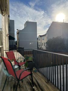 two chairs on a balcony with the sun in the background at MyCrib Houston Hostel in Houston