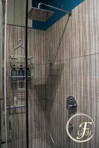 ducha con puerta de cristal y cabezal de ducha en Fenty Guest House en Roma