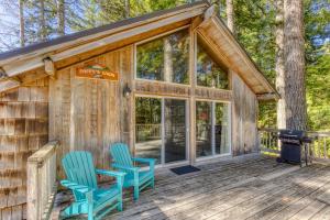 una cabina nel bosco con due sedie blu su una terrazza di Pappy's Cabin a Welches
