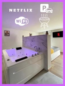 Habitación con baño con bañera púrpura. en LOFT Jardin et Spa, en Bressuire
