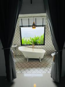 a bathroom with a large window and a bath tub at ริมยมรีสอร์ท in Ban Wang Din