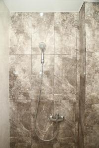 um chuveiro na casa de banho com uma parede de pedra em Istanaku em Manado