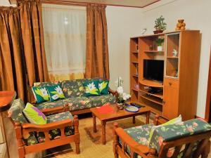 a living room with a couch and a table at HUAHINE - Hibiscus House in Haapu