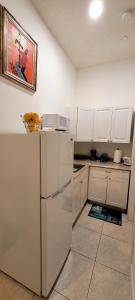 eine Küche mit einem weißen Kühlschrank und einer Mikrowelle in der Unterkunft Villa Las Palmeras South Miami in Miami