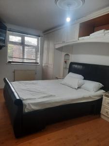 1 dormitorio con 1 cama grande con sábanas blancas en Home Away in a Close en Thamesmead