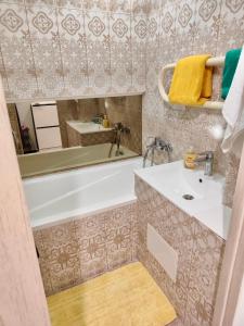 a bathroom with a tub and a sink and a mirror at Dream Apartment in Jelgava