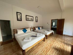 um quarto de hotel com duas camas e um espelho em Kep Lodge em Kep
