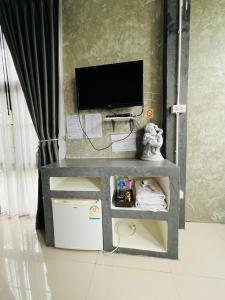 een woonkamer met een tv en een tafel met een televisie bij ริมยมรีสอร์ท in Ban Wang Din