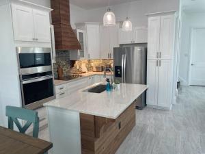 a white kitchen with a sink and a refrigerator at Beach Glass - Island Getaway in Corpus Christi