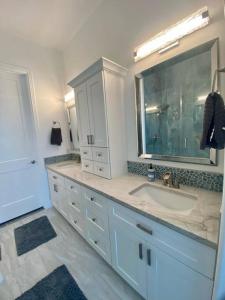 a bathroom with a sink and a large mirror at Beach Glass - Island Getaway in Corpus Christi