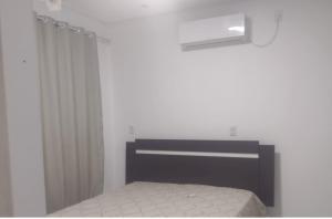 um quarto com uma cama e uma cortina de chuveiro em Casa de Praia da Lara em Piúma