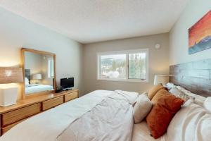 ein Schlafzimmer mit einem großen Bett und einem Spiegel in der Unterkunft Big Horn by DC in Big Sky