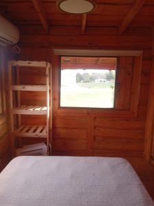 a room with a bed and a window in a cabin at Cabaña El Cardenal in Tandil