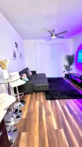 un soggiorno con divano nero e pavimenti in legno di Modern comfort at The Domain Austin ,Texas ad Austin