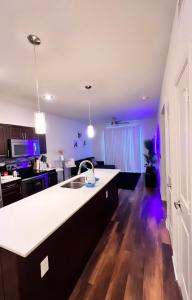 a kitchen with a sink and a kitchen with purple lights at Modern comfort at The Domain Austin ,Texas in Austin