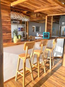 a bar with four wooden stools in a kitchen at Solarium Beach Club in Playa Blanca