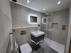 y baño con lavabo, ducha y aseo. en Sunset Point Apts - Blue Horizon Suite en Margate