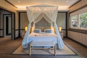 a bedroom with a bed with a canopy at Lembeh Resort in Bitung