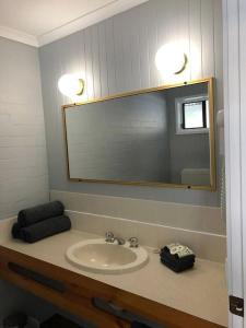 bagno con lavandino e specchio di Country Roads Motor Inn a West Wyalong