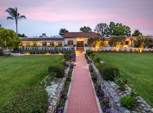 a house with a red brick walkway in front of a yard at The Inn at Rancho Santa Fe in Rancho Santa Fe