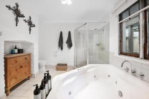 a white bathroom with a tub and a window at The Historic Old Pharmacy Hockeys - Millthorpe in Millthorpe