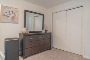 - une chambre avec une commode et un miroir dans l'établissement Executive Apartment in Fairbanks, à Fairbanks