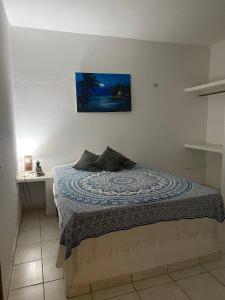 um quarto com uma cama com uma fotografia na parede em Morada dos Ventos em Fortaleza