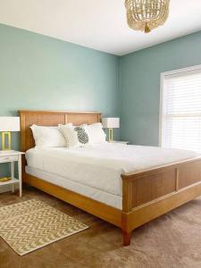 Un dormitorio con una cama grande con paredes azules y una lámpara de araña. en Large 4bed/4bath Home + 2 Airstream Glampers & Spa Midway to Tybee Beach & Downtown Savannah with Fast WiFi and More! en Savannah