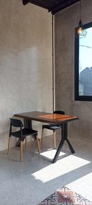 drewniany stół i ławka oraz stół i okno w obiekcie Nia room w mieście Kerobokan