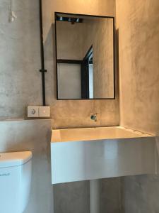 Łazienka z lustrem i białą toaletą w obiekcie Nia room w mieście Kerobokan
