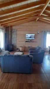 ein Wohnzimmer mit 2 blauen Sofas und einem TV in der Unterkunft Casa Loncoche Villarrica con 3 Dormitorios in Loncoche