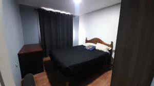 ein Schlafzimmer mit einem schwarzen Bett und einem schwarzen Vorhang in der Unterkunft Casa Loncoche Villarrica con 3 Dormitorios in Loncoche