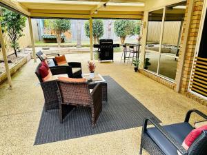 a patio with a couch and chairs and a table at Ocean Breeze Family Getaway - Short drive to Beach & Adventure Park in Ocean Grove