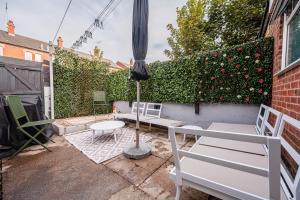 a patio with an umbrella and a table and chairs at SuffStay in Ipswich