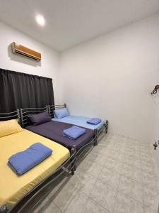 Zimmer mit 2 Betten in einem Zimmer in der Unterkunft Juzt Homestay Kpg Boyan in Taiping