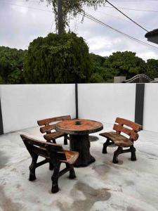 ein Tisch und zwei Stühle neben einem Baumstumpf in der Unterkunft Juzt Homestay Kpg Boyan in Taiping