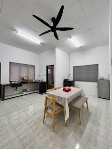 eine Küche mit einem Tisch und einem Deckenventilator in der Unterkunft Juzt Homestay Kpg Boyan in Taiping