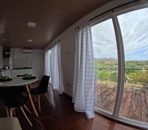 sala de estar con mesa y ventana grande en La Loma en Villa Giardino