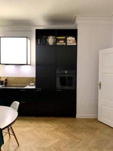 a kitchen with a black cabinet with a microwave at Christianshavn Canalside Luxury Apartment in Copenhagen