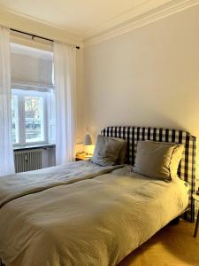 sypialnia z dużym łóżkiem i oknem w obiekcie Christianshavn Canalside Luxury Apartment w Kopenhadze