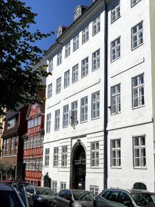 duży biały budynek z łukowymi drzwiami w obiekcie Christianshavn Canalside Luxury Apartment w Kopenhadze