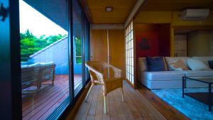 熱海的住宿－Alivio ATAMI，一个带沙发和桌子的门廊