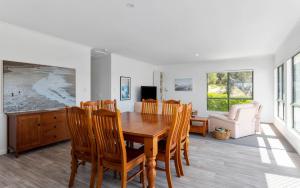 uma sala de jantar com uma mesa de madeira e cadeiras em Great Family Holiday House in Central Location em Victor Harbor