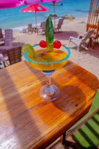 a drink sitting on a wooden table on the beach at Solarium Beach Club in Playa Blanca