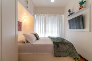 um quarto com uma cama e uma janela em Vinicius de Moraes Ipanema Apartment no Rio de Janeiro